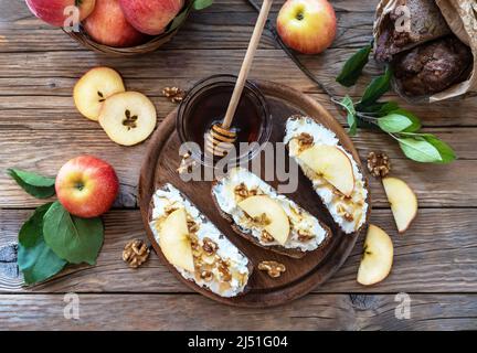 Bread slices with cottage cheese, honey, apples and nuts in rustic style Stock Photo