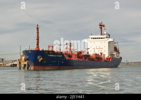 Bulk oil tanker moored at dock in Portsmouth, Hampshire, England. 'Cumbrian Fisher' Viewed from boat on the water. Stock Photo