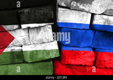 Concept of the relationship between Palestine and Russia with two painted flags on a damaged brick wall Stock Photo