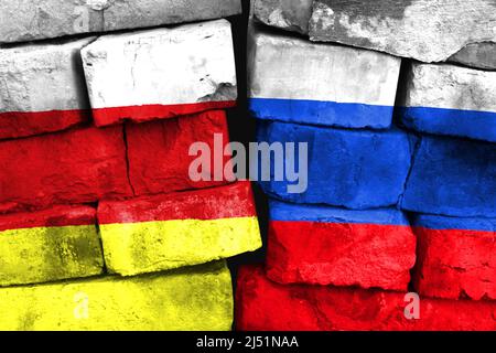 Concept of the relationship between South Ossetia and Russia with two painted flags on a damaged brick wall Stock Photo