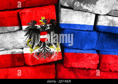 Concept of the relationship between Austria and Russia with two painted flags on a damaged brick wall Stock Photo