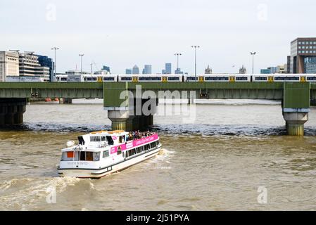 Sightseeing pleasure boat on the River Thames passing under Cannon Street railway bridge, London, UK, April Stock Photo