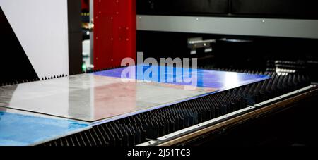 Metal sheet on production line of laser cutting machine. Industrial metalworking machinery. Stock Photo
