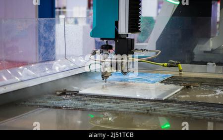 Modern CNC Abrasive water jet cutting machine using high pressure water jet to cut metal. Industrial metalworking machinery. Stock Photo