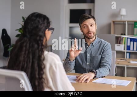 Two colleagues brainstorming for business ideas, discussing startup project at modern office Stock Photo