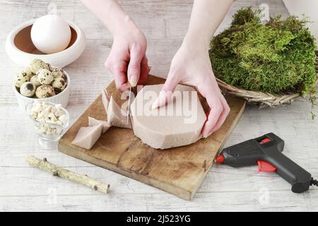 Florist at work: How to make beautiful Easter decoration in tree shape with moss and quail eggs. Step by step, tutorial. Stock Photo