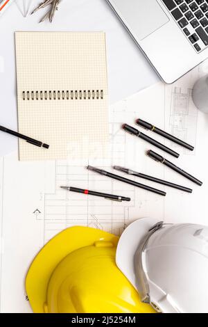 Mockup of architectural concept, Drawing tool and coffee on drawing of blueprint with safety helmet. Stock Photo