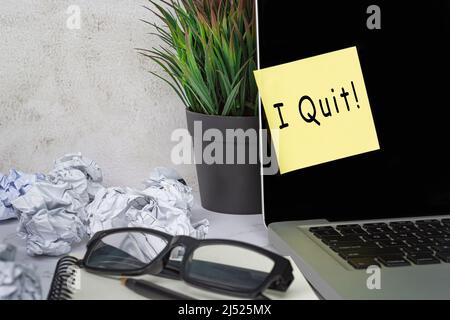 I quit text on sticky note on laptop . Concept of decision making to quit job and to resign. Stock Photo