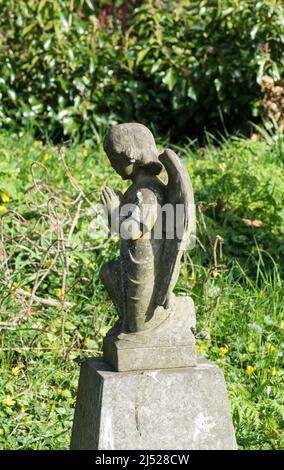 Small carved stone angel on grave stone Stock Photo