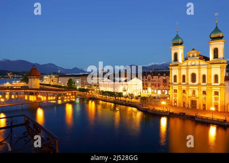 Lucerne, Switzerland - May 06, 2016: Night view of towards Jesuit Church, Jesuitenkirche and made of stone octagonal tower, Wasserturm located by the Stock Photo