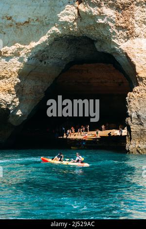 Benagil, Algarve, Portugal - April 15, 2022: Tourists on kayaks visit the Benagil cave in Benagil, Portugal Stock Photo