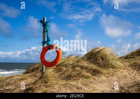 A tethered Life Buoy blowing in the sea breeze in Embleton Bay sand dunes, Northumberland Coast, England Stock Photo