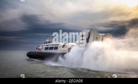 A hovercraft sets off at dusk from Southsea beach for the Isle of Wight, a journey that takes less than 10 minutes. Stock Photo