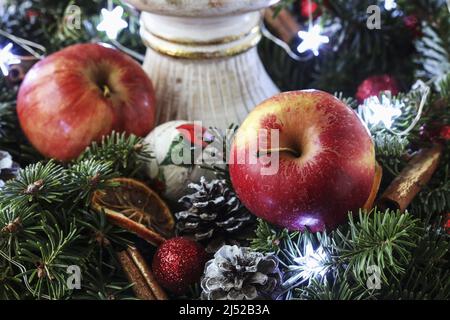 Two red apples on a big traditional Christmas wreath. Festive decor Stock Photo