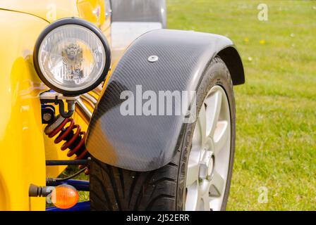 Headlight and front wheel of a yellow Caterham Seven Roadsport Stock Photo
