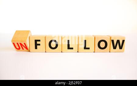 Follow or unfollow symbol. Turned wooden cubes and changed concept words Follow to Unfollow. Beautiful white table white background. Business and foll Stock Photo