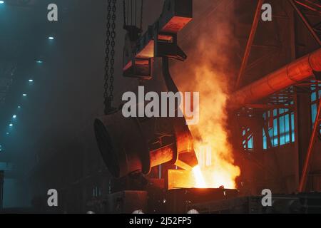 Metal pouring with sparks. Smelting of cast iron parts in foundry. Metallurgical plant or Steel Mill. Stock Photo