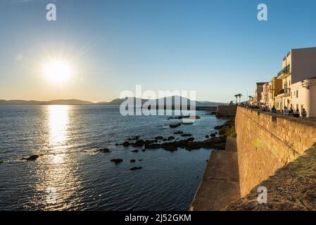 Beautiful cities in Sardinia - sunset over the bay, harbour, colourful facades and the promenade on the fortress wall at the old town of Alghero Stock Photo