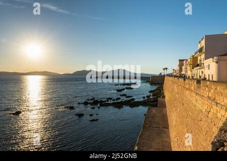 Beautiful cities in Sardinia - sunset over the bay, harbour, colourful facades and the promenade on the fortress wall at the old town of Alghero Stock Photo