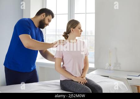 Professional chiropractor or physiotherapist helping patient who's undergoing rehabilitation Stock Photo