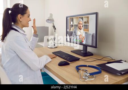 Female general practitioner provides online consultation to her sick patient via video call. Stock Photo