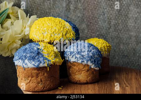 Delicious Easter cakes on a wooden table with flowers in the background. place for text. selective focus Stock Photo