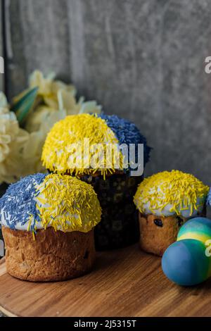 Delicious Easter cakes on a wooden table with flowers in the background. place for text. selective focus Stock Photo