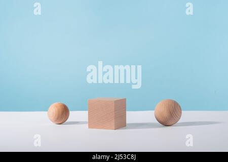 Wooden cube podium with sphere on blue background for cosmetic or jewellery showcase. Creative geometric product stage mock up, cosmetics display Stock Photo