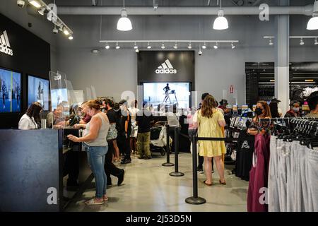 Kietelen groentje Wens People seen shopping inside an Adidas store at The Outlets in Orange. Many  people shop at