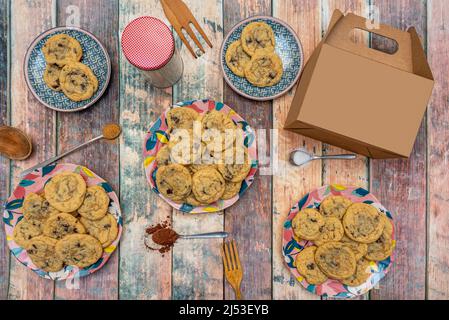 Plates full of chocolate chip cookies with cardboard box for home delivery Stock Photo