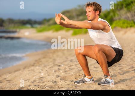 Fitness workout fit man strength training doing squats on beach. Lower body legs exercises athlete Stock Photo