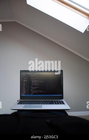 Opened laptop with code on the screen on the table Stock Photo