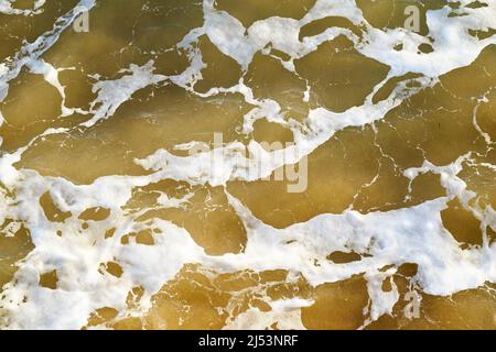 Brown sea water abstract with white bubbles Stock Photo