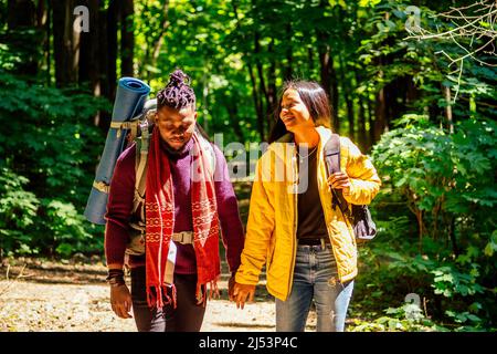 latin american man and hispanic woman in a forest having a rest . Stock Photo
