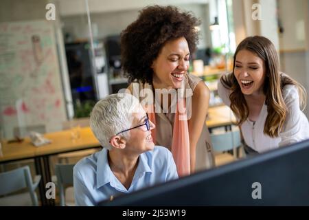 Group of software engineers working developing applications together in corporate office Stock Photo