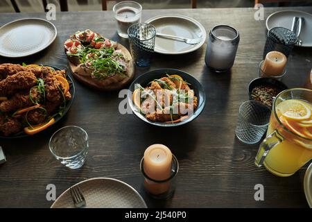 Image of dining table with dish and appetizers on it preparing for holiday dinner with candles Stock Photo