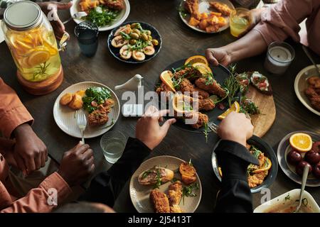 High angle view of family sitting at dining table and eating chicken together during holiday event Stock Photo