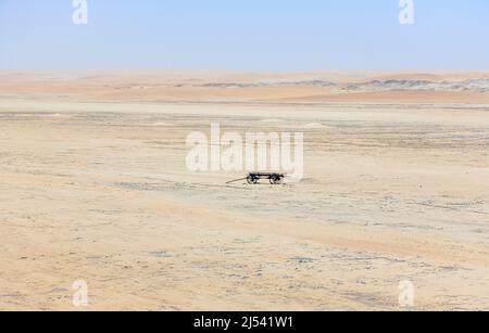 An abandoned, disintegrating wooden cart stands in the sand of the vast, arid Namib Desert Skeleton Coast, near Swakopmund, Namibia, south-west Africa Stock Photo