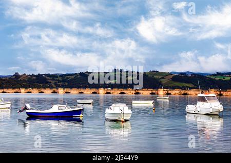 Views of the bridge of the fishing village of San Vicente de la Barquera with the boats in the port. Cantabria, Spain Stock Photo