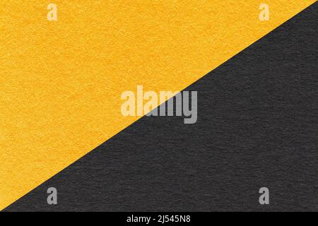 Texture of craft yellow and black paper background, half two colors, macro. Structure of vintage dense craft cardboard. Felt backdrop closeup. Stock Photo