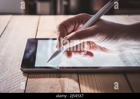 Casual business woman hand using stylus pencil and work on digital tablet computer pc at home. Online working concept. Stock Photo