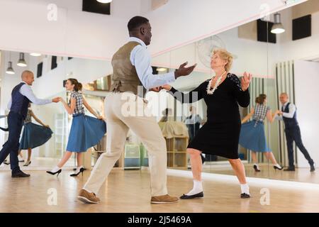 Lady learning to dance lindy hop with man in dance school Stock Photo