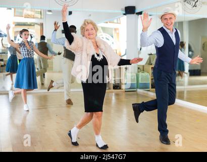 Mature woman dancing swing with young man Stock Photo
