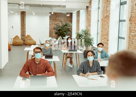Multi ethnic students are listening to a lecturer Stock Photo