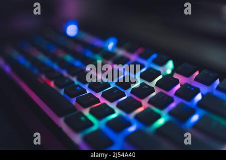 Colourful illuminated gamer keyboard with black push-bottoms. Red, green, blue, pink. High quality photo Stock Photo