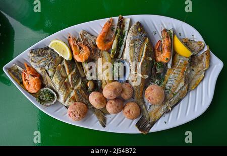 Typical fish plate with different grilled fishes, cockles, razor clams, prawns, Canarian potatoes and supplements, Canary Islands, Lanzarote Stock Photo