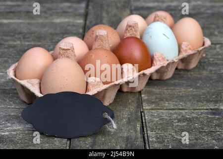 empty chalkboard in front of chicken eggs in the egg carton, Germany Stock Photo
