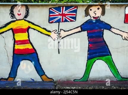 children hold British flag, graffiti on a wall Stock Photo
