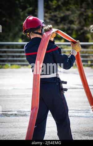 person holding a fire hose during a drill Stock Photo