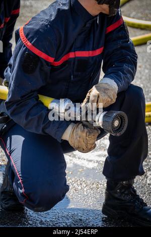 person holding a fire hose during a drill Stock Photo